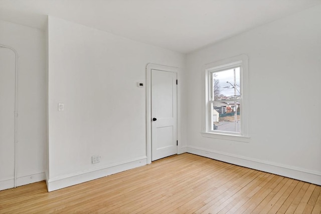 spare room featuring hardwood / wood-style flooring and baseboards