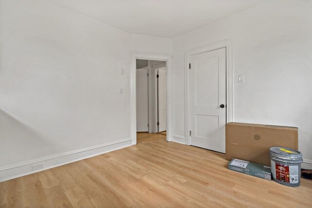 unfurnished room with baseboards and wood finished floors