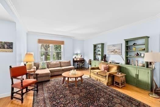 living room with crown molding and light wood-style flooring