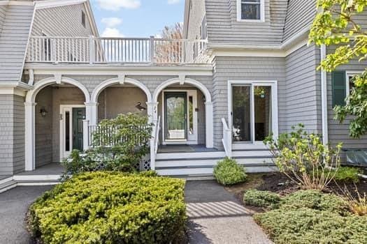 entrance to property with covered porch and a balcony