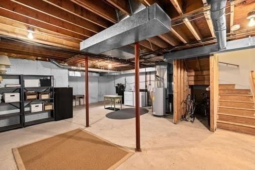 unfinished below grade area with washer / clothes dryer, water heater, and stairway