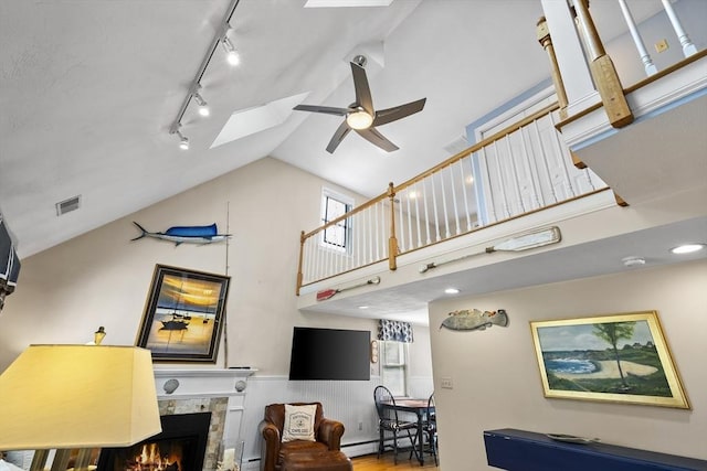 28 Chestnut St, Falmouth, MA 02536 - living area featuring a baseboard heating unit, a ceiling fan, track lighting, a tile fireplace, and high vaulted ceiling