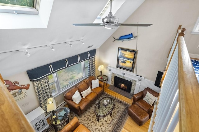 28 Chestnut St, Falmouth, MA 02536 - living area with ceiling fan, a glass covered fireplace, wood finished floors, vaulted ceiling, and track lighting