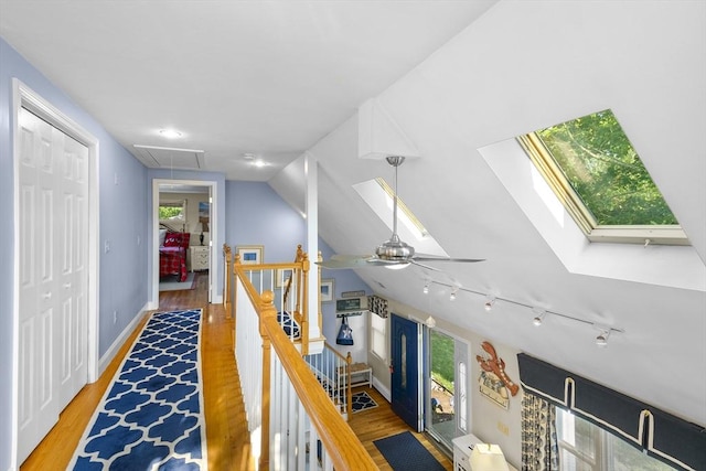 28 Chestnut St, Falmouth, MA 02536 - corridor featuring an upstairs landing, attic access, track lighting, wood finished floors, and vaulted ceiling