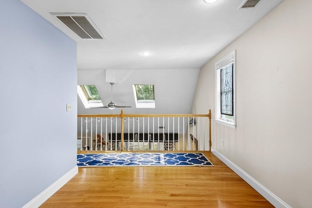 28 Chestnut St, Falmouth, MA 02536 - hallway featuring a skylight, wood finished floors, and an upstairs landing