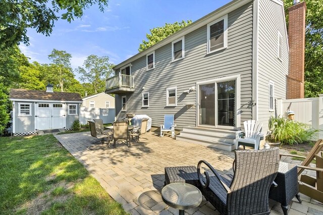 28 Chestnut St, Falmouth, MA 02536 - back of house with entry steps, a balcony, an outbuilding, a patio, and a chimney