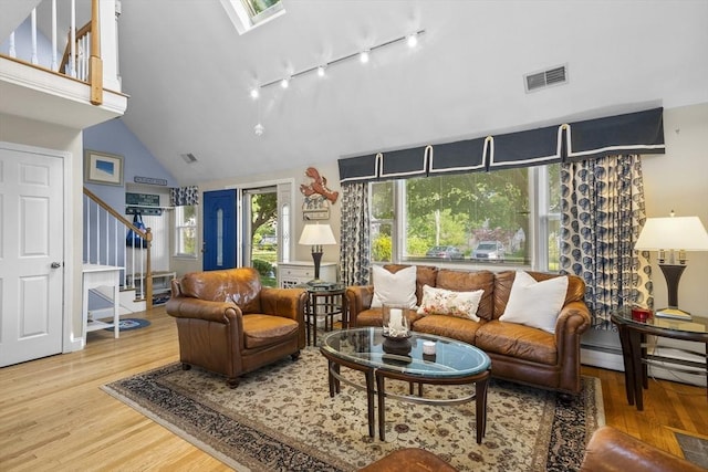 28 Chestnut St, Falmouth, MA 02536 - living area featuring stairs, wood finished floors, track lighting, high vaulted ceiling, and a skylight