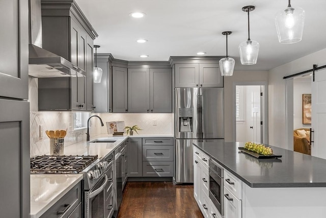 32 Gilman Rd, Billerica, MA 01862 - kitchen with stainless steel appliances, wall chimney exhaust hood, a barn door, a sink, and gray cabinetry