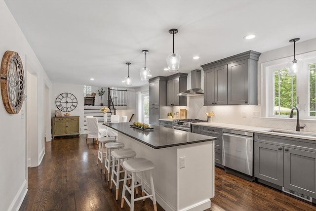 32 Gilman Rd, Billerica, MA 01862 - kitchen featuring appliances with stainless steel finishes, wall chimney range hood, gray cabinetry, a sink, and tasteful backsplash