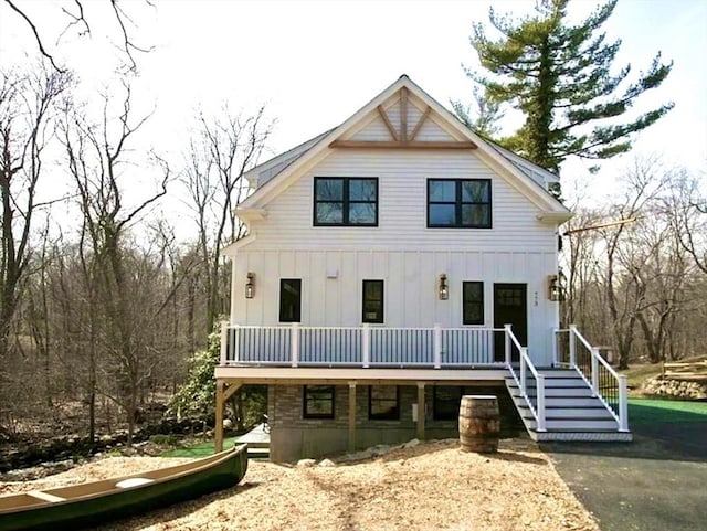 view of front of property with stairs, a deck, and board and batten siding