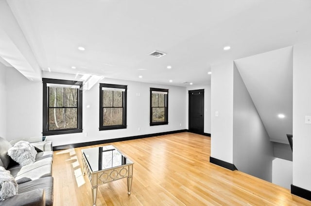 living room featuring recessed lighting, baseboards, visible vents, and light wood-type flooring