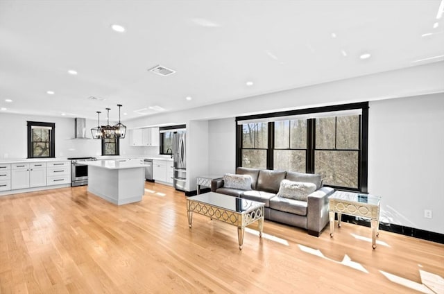 living room with recessed lighting, baseboards, a chandelier, visible vents, and light wood-style flooring