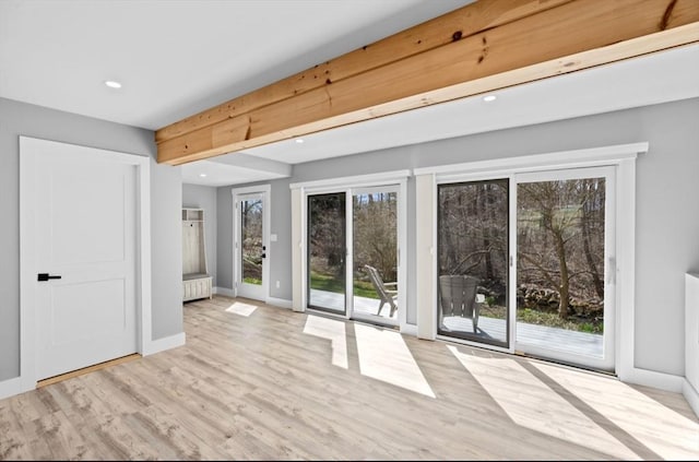empty room with baseboards, wood finished floors, recessed lighting, and radiator