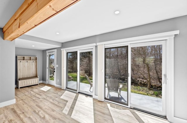 doorway with baseboards, wood finished floors, and recessed lighting