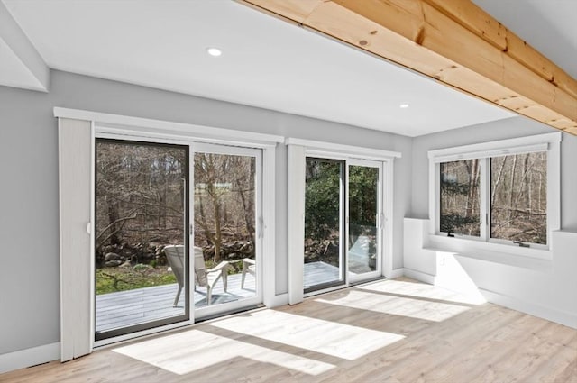 doorway featuring baseboards, wood finished floors, and recessed lighting