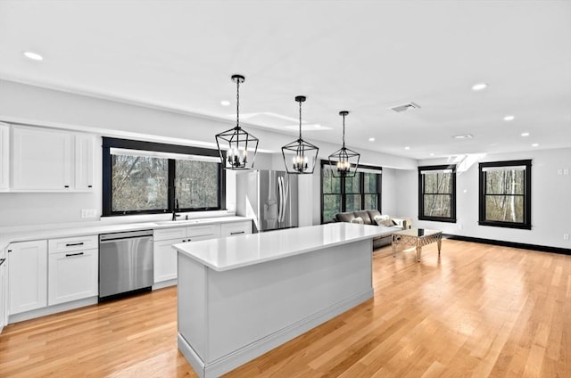 kitchen with light countertops, white cabinets, a sink, and appliances with stainless steel finishes