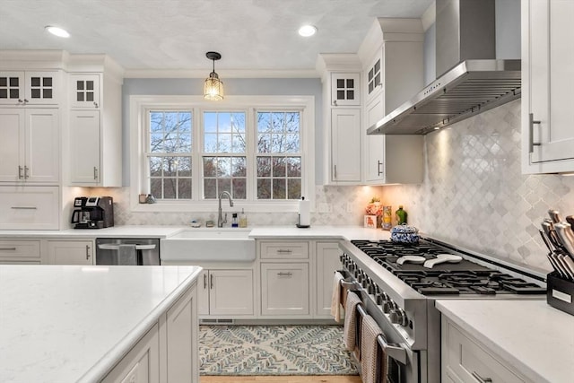 kitchen featuring white cabinetry, stainless steel appliances, wall chimney exhaust hood, and hanging light fixtures