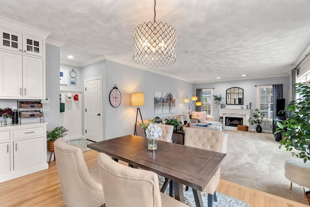 dining space featuring a chandelier, recessed lighting, a high end fireplace, and light wood-style floors