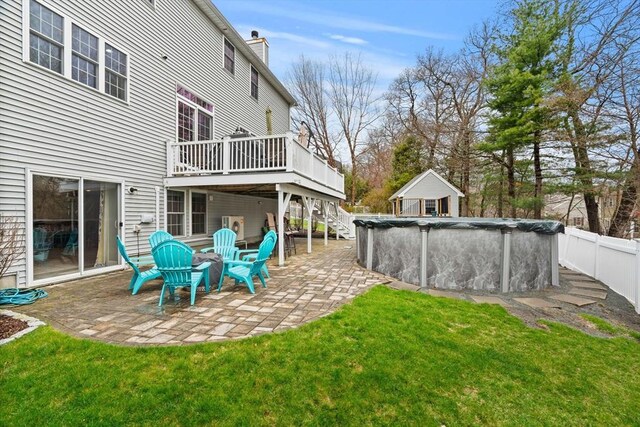 rear view of house with a covered pool, a patio area, a yard, a deck, and fence