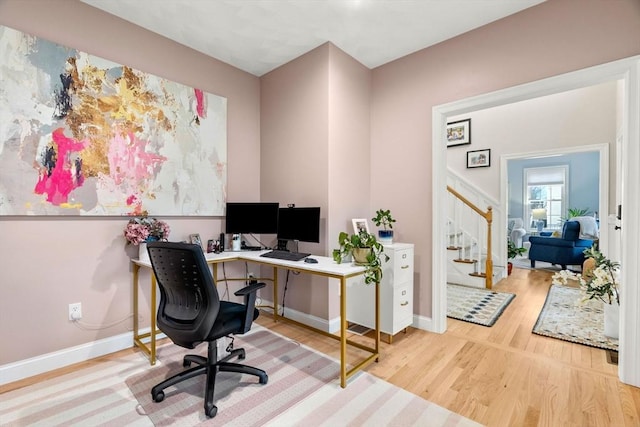 office area with baseboards and wood finished floors