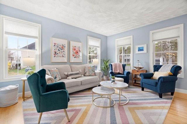 living room featuring baseboards, wood finished floors, and a textured ceiling