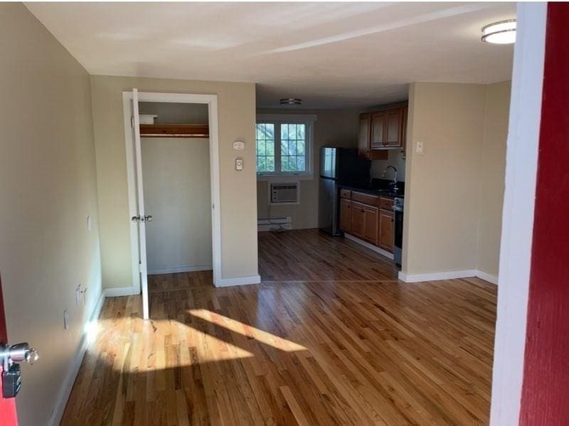 35 Parker Rd Unit 26, Falmouth, MA 02536 - kitchen featuring wood finished floors, a baseboard heating unit, baseboards, and freestanding refrigerator