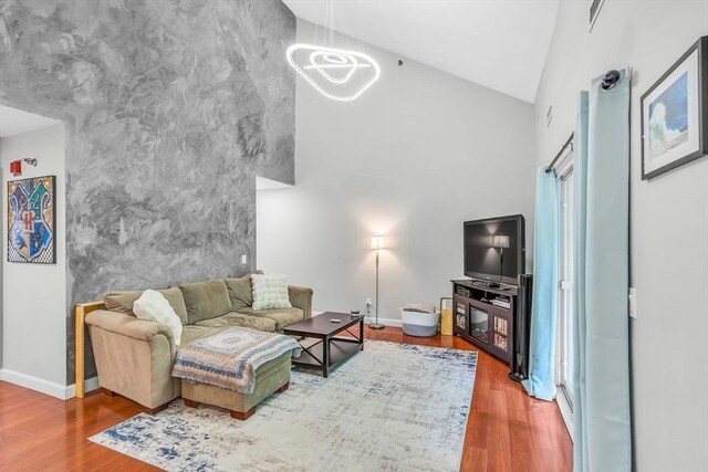 124 Tennis Plaza Rd Unit 2, Dracut, MA 01826 - living area with high vaulted ceiling, wood finished floors, and an accent wall