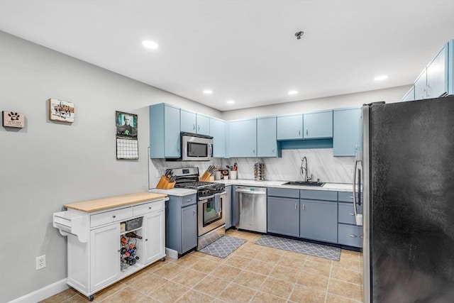 124 Tennis Plaza Rd Unit 2, Dracut, MA 01826 - kitchen featuring appliances with stainless steel finishes, tasteful backsplash, light countertops, recessed lighting, and blue cabinetry