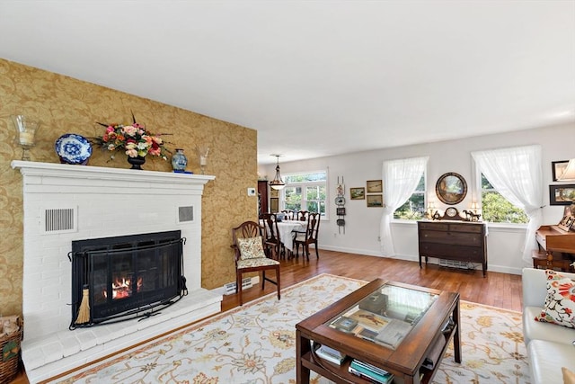 39 Bennets Neck Dr, Bourne, MA 02559 - living area with wood finished floors, a fireplace, and wallpapered walls
