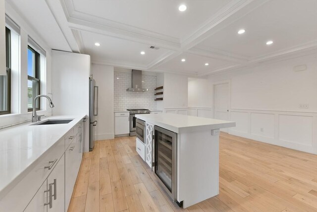 126 Central St Unit 2, Somerville, MA 02145 - kitchen with wall chimney exhaust hood, wine cooler, a kitchen island, stainless steel appliances, and ornamental molding
