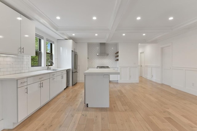 126 Central St Unit 2, Somerville, MA 02145 - kitchen featuring appliances with stainless steel finishes, wall chimney exhaust hood, white cabinetry, ornamental molding, and a kitchen island