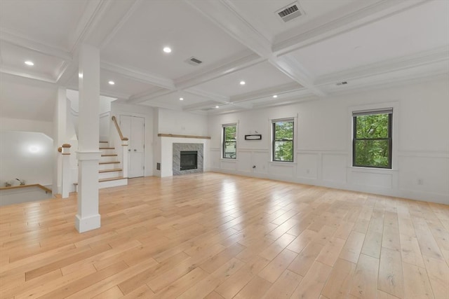 126 Central St Unit 2, Somerville, MA 02145 - unfurnished living room featuring coffered ceiling, beam ceiling, light wood-style flooring, stairway, and a fireplace