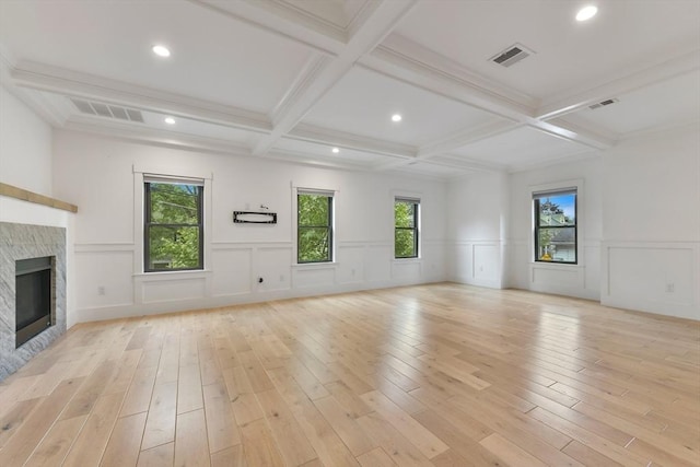 126 Central St Unit 2, Somerville, MA 02145 - unfurnished living room with light wood-type flooring, beamed ceiling, a fireplace, coffered ceiling, and a decorative wall