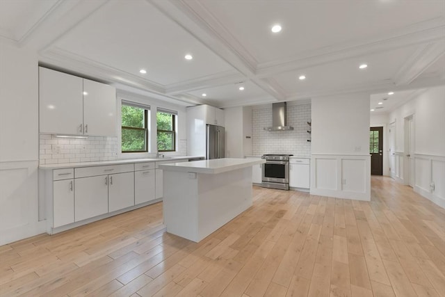 126 Central St Unit 2, Somerville, MA 02145 - kitchen featuring stainless steel appliances, wall chimney range hood, white cabinetry, light countertops, and beamed ceiling