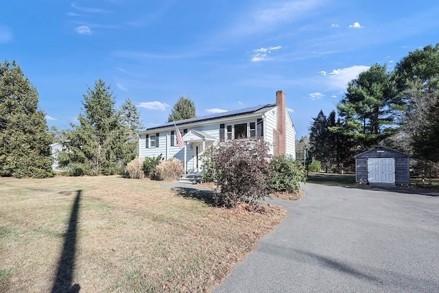 bi-level home with a storage shed and a front lawn