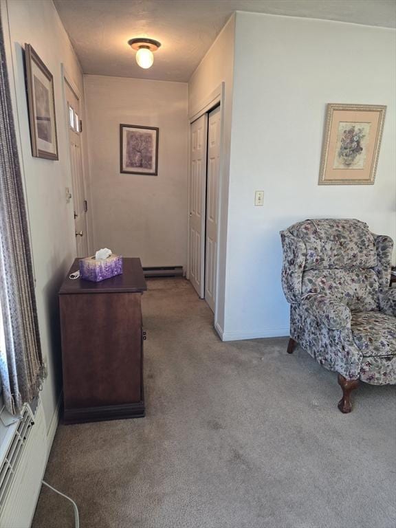 hallway featuring a baseboard heating unit, baseboard heating, and carpet flooring