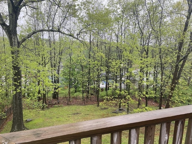 view of green lawn featuring a wooded view