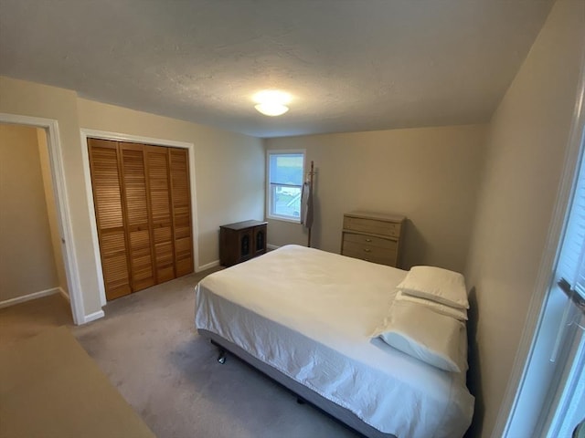carpeted bedroom with baseboards, a closet, and a textured ceiling