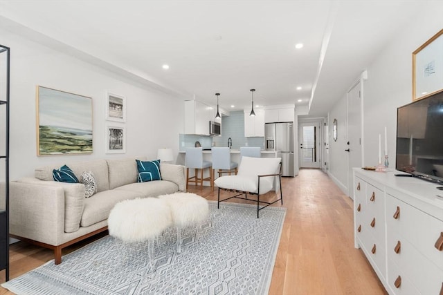 living room featuring light hardwood / wood-style floors and sink