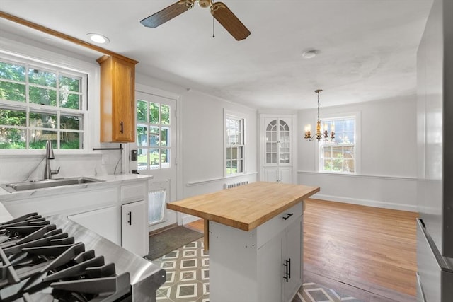 31 Whitman Ave, Melrose, MA 02176 - kitchen featuring a sink, wood counters, a ceiling fan, a chandelier, and baseboards