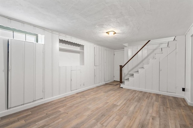 31 Whitman Ave, Melrose, MA 02176 - basement featuring light wood-type flooring, stairway, baseboards, and a textured ceiling