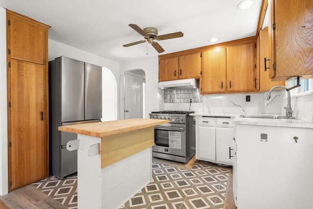 31 Whitman Ave, Melrose, MA 02176 - kitchen featuring stainless steel appliances, a sink, under cabinet range hood, a ceiling fan, and arched walkways