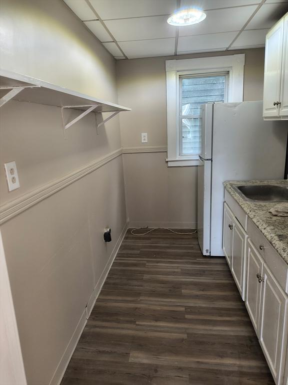 43 Cedar St, Lowell, MA 01852 - kitchen featuring a drop ceiling, dark wood finished floors, white cabinetry, baseboards, and light stone countertops