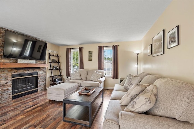 living area featuring dark wood finished floors and a stone fireplace