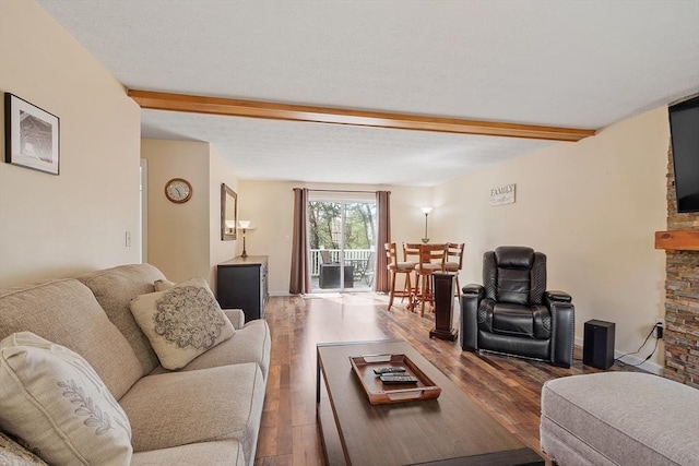 living area with beam ceiling and wood finished floors