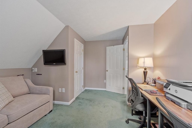 carpeted home office featuring baseboards and vaulted ceiling
