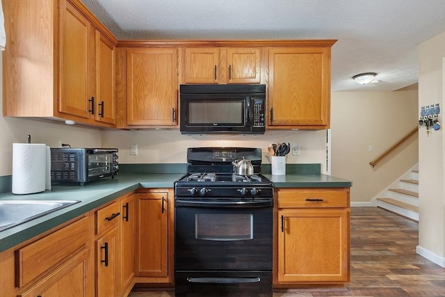 kitchen featuring black appliances, dark wood-type flooring, brown cabinetry, baseboards, and dark countertops