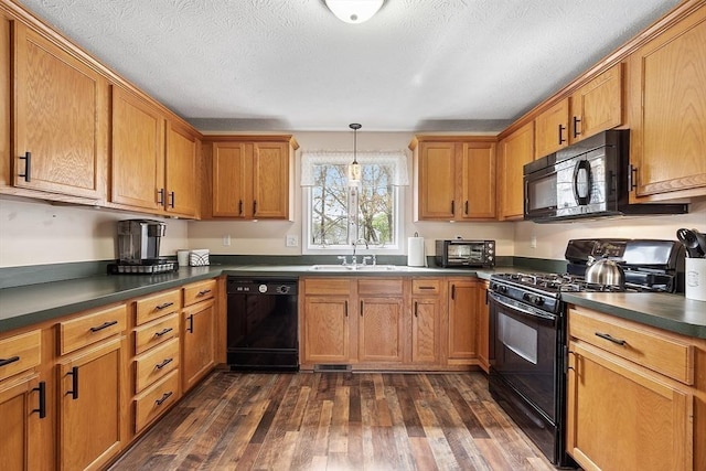 kitchen featuring black appliances, a sink, dark countertops, dark wood finished floors, and brown cabinets