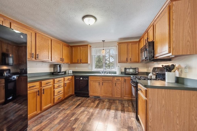 kitchen with black appliances, dark wood-type flooring, dark countertops, brown cabinets, and a textured ceiling