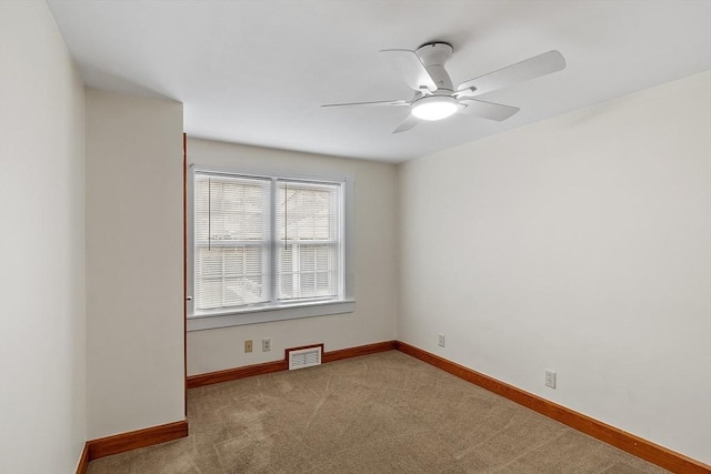 carpeted spare room featuring ceiling fan